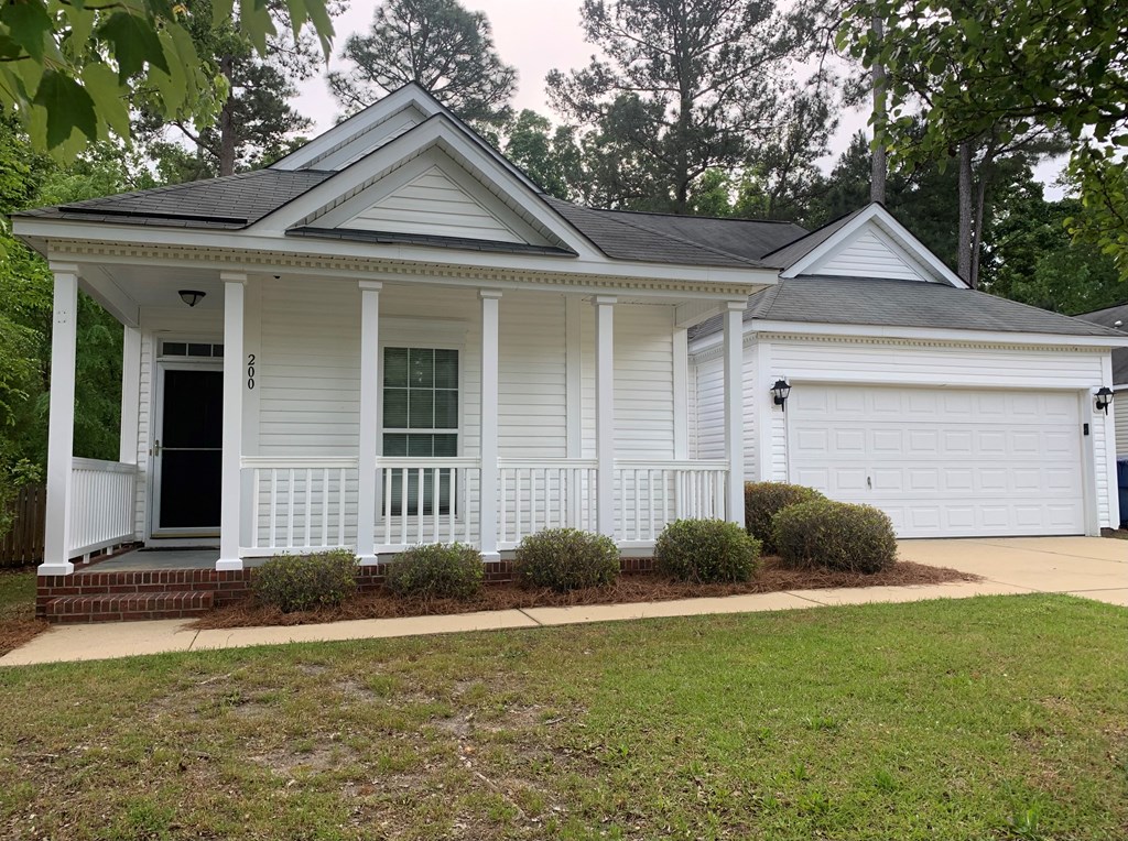 a white house with a front porch and a lawn