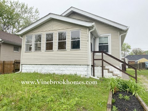 the front of a house with a yard and stairs