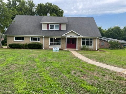 A house with a red door is for sale.