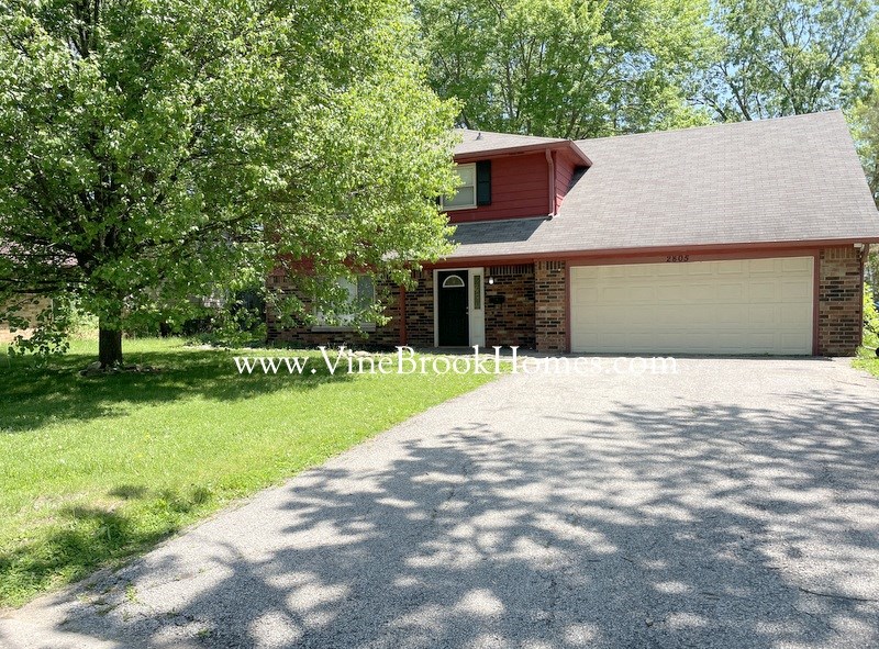 a driveway in front of a house with a garage door