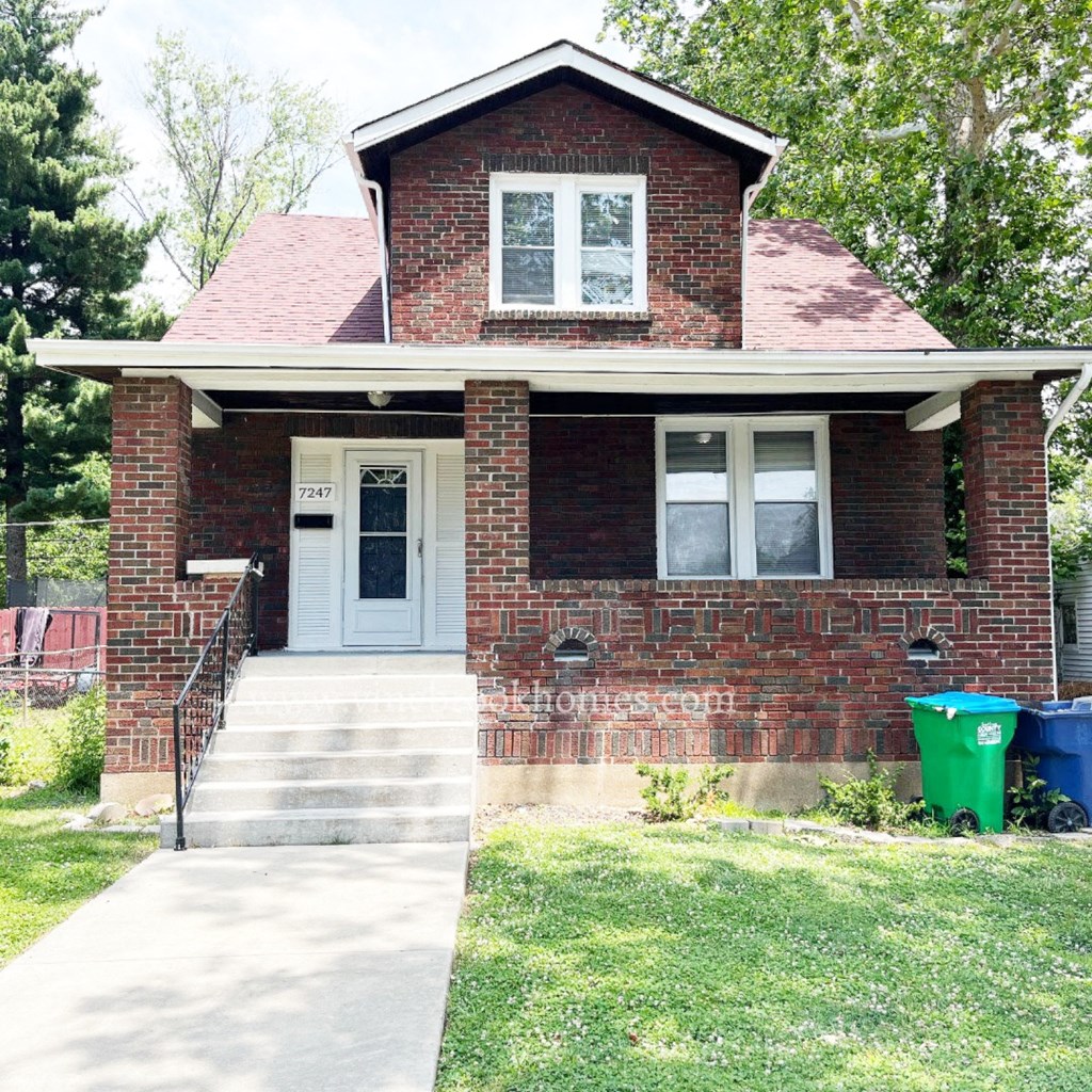 a small brick house with a blue front door