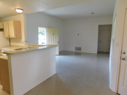 A kitchen with white walls and a counter top.