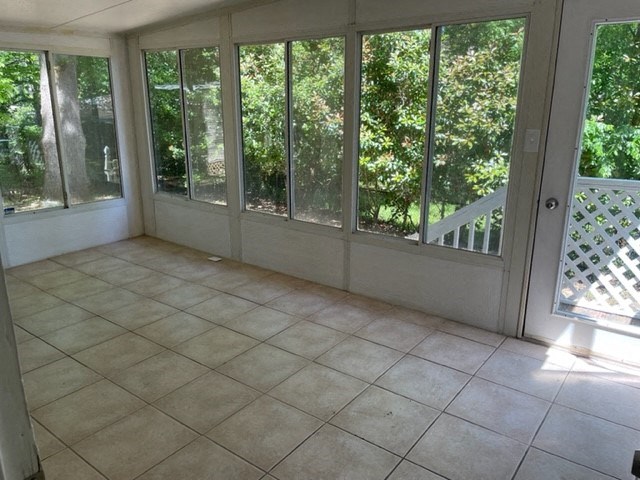 a living room with large windows and a tiled floor