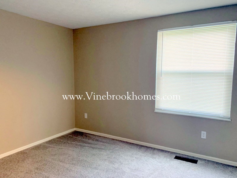 a small room with a large window and a carpet