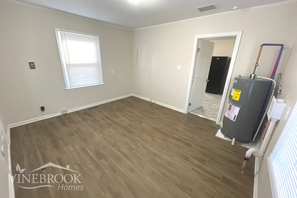 the living room with hardwood flooring and a suitcase in the corner