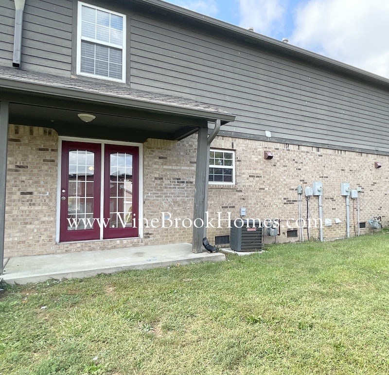 a house with a red door and a brick wall