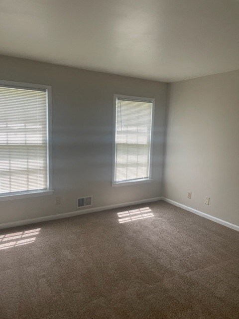 an empty room with two windows in it