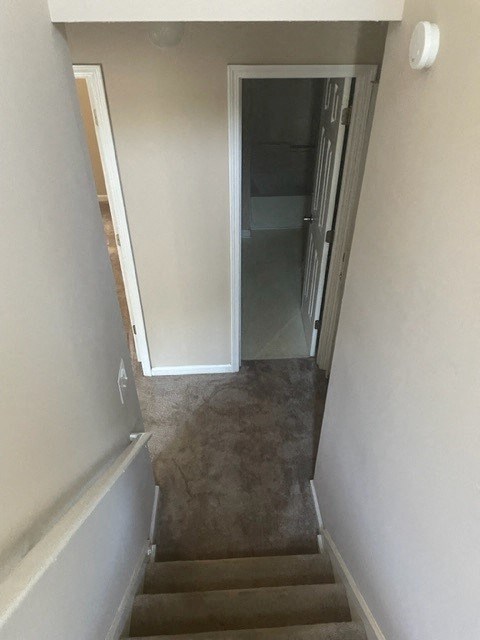 a hallway with stairs and a door to a room