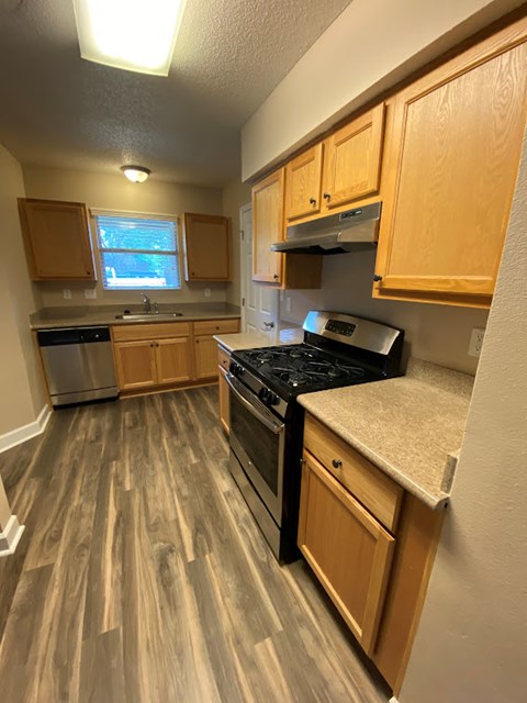 A kitchen with wooden cabinets and a black countertop.