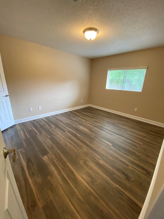 A room with wooden flooring and a window.