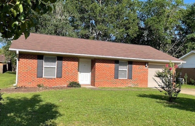A red brick house with a white door and window.