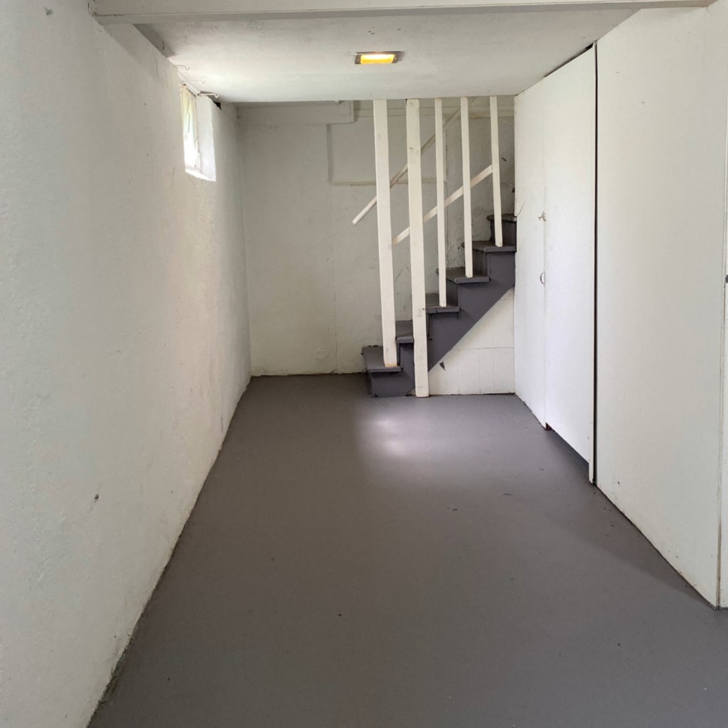 a white room with stairs and a gray floor