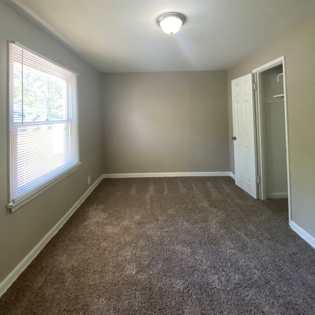 a empty room with carpet and a window