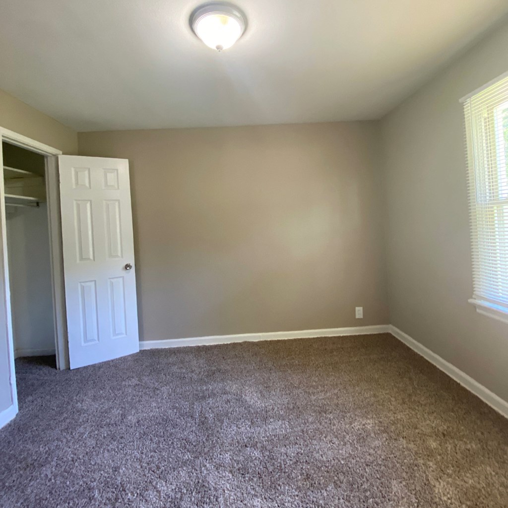 an empty room with carpet and a door