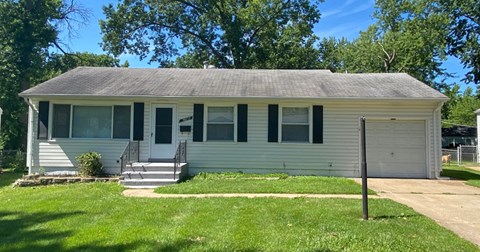 a white house with a porch and a lawn