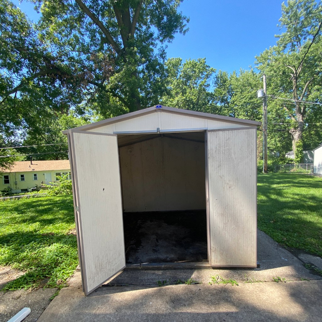a small wooden shed with the door open