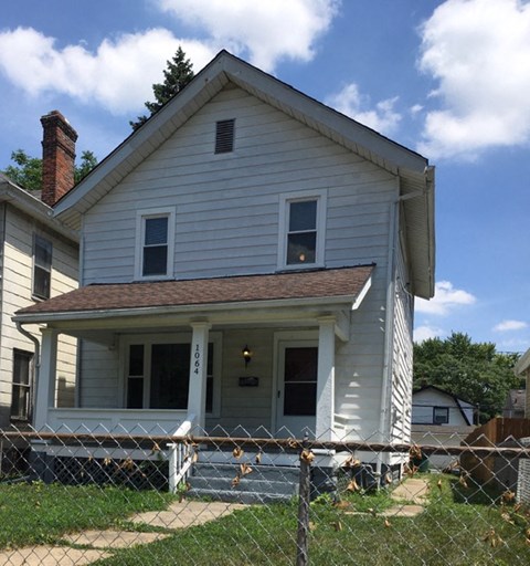 a white house with a fence in front of it