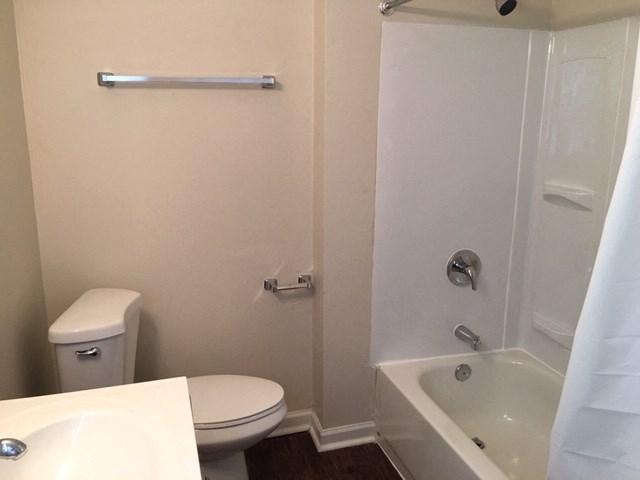 a bathroom with a toilet and a tub and a sink