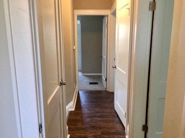 a hallway with a wood floor and white doors