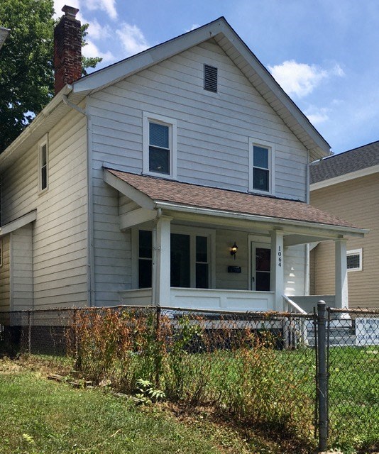a white house with a fence in front of it