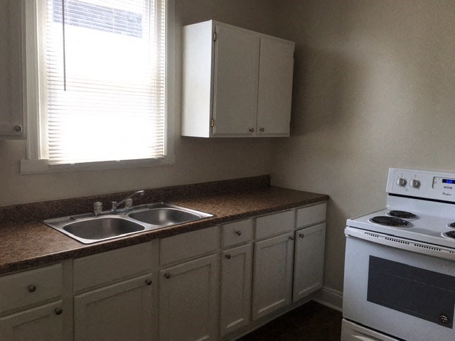a kitchen with a sink and a stove and a window