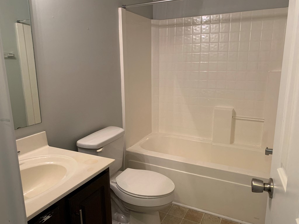 a bathroom with a toilet and a tub and a sink