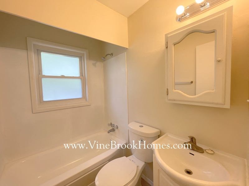 a bathroom with a toilet and a sink and a window