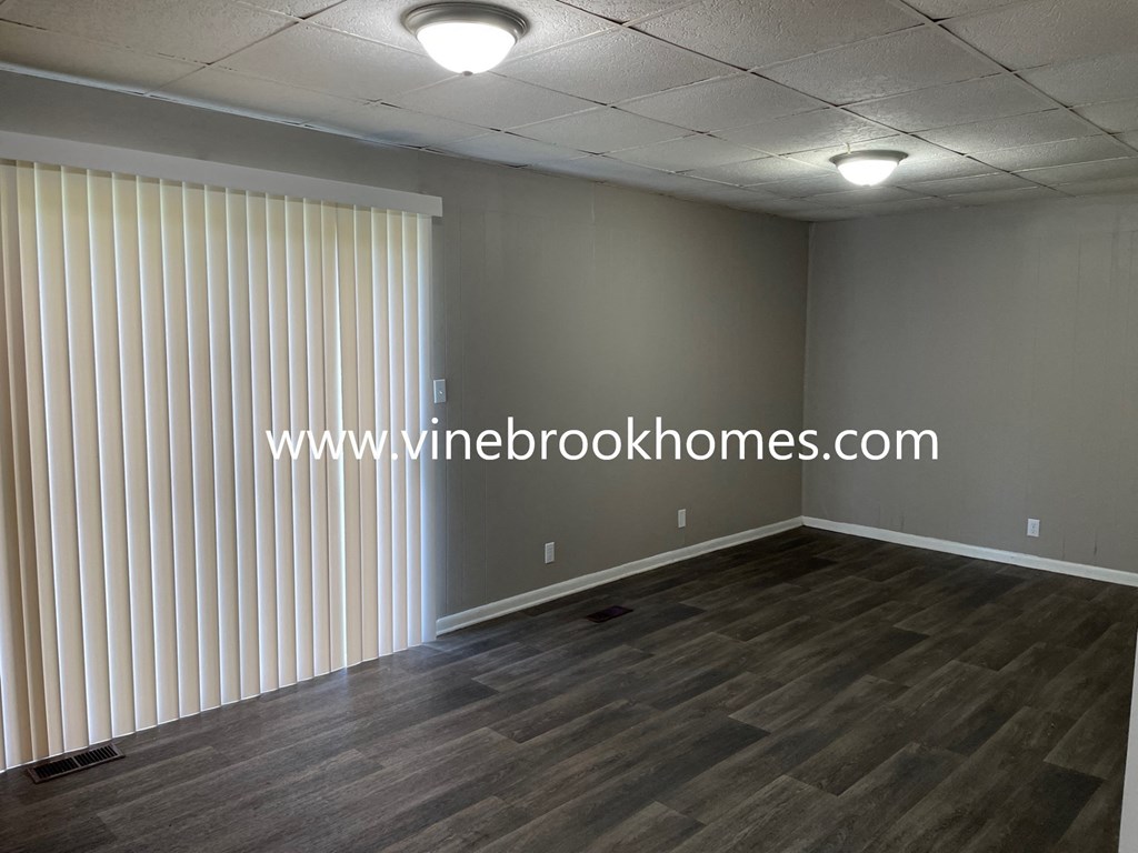 a living room with white vertical blinds on the window