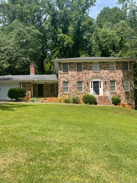a brick house with a green lawn in front of it