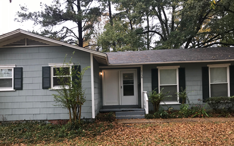 A house with a grey front and a white door.