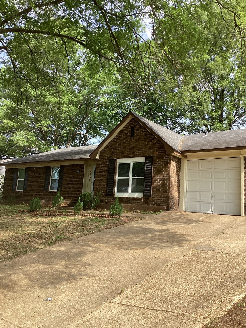 A house with a white garage door and a brown brick exterior.