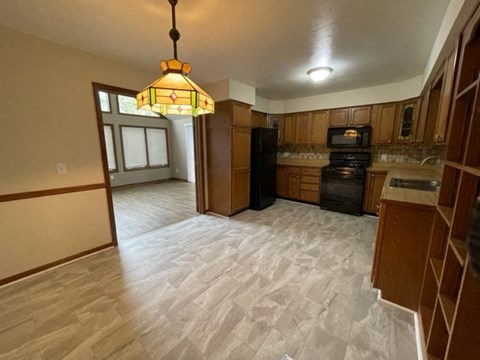 A kitchen with wooden cabinets and a black stove top oven.