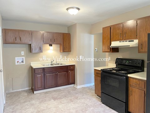 a kitchen with black appliances and wooden cabinets
