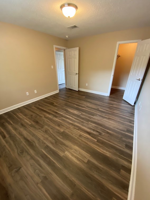 A room with wooden flooring and two white doors.