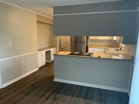 A kitchen with white cabinets and a black countertop.