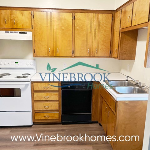 a kitchen with white appliances and wooden cabinets