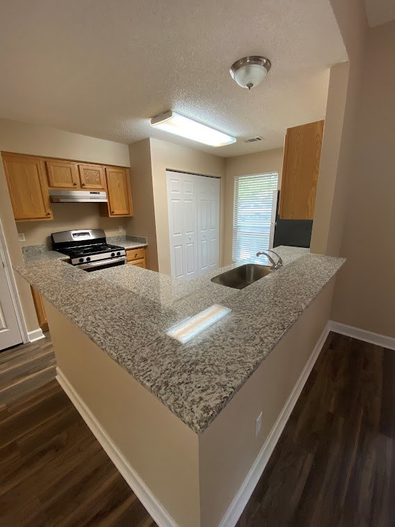 A kitchen with granite countertops and wooden cabinets.