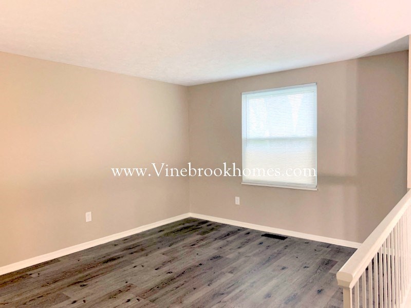 a small white room with wooden floors and a window