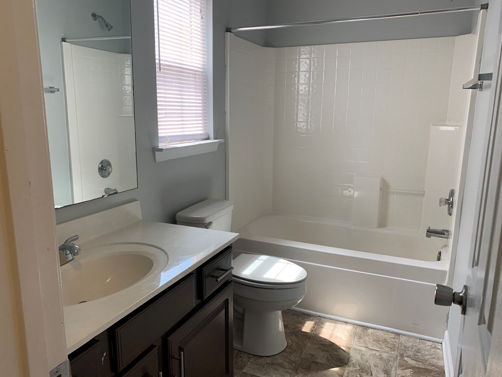 a bathroom with a toilet and a tub and a sink