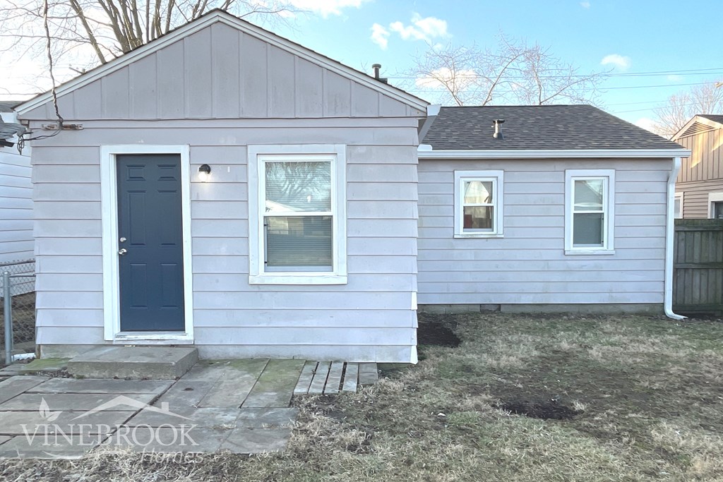 the front of a white house with a blue door