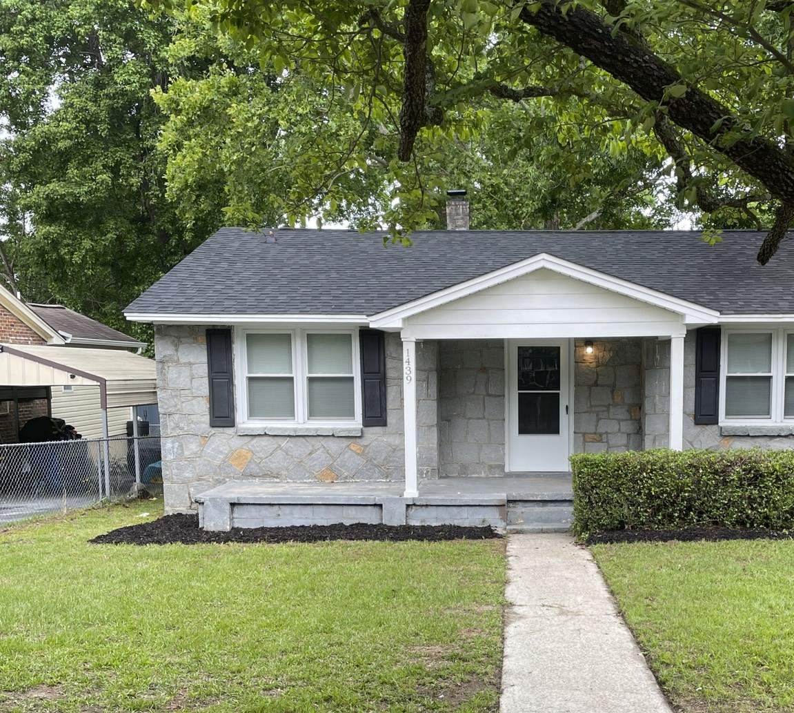 A small house with a grey roof and white trim.