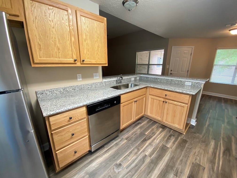 A kitchen with wooden cabinets and a granite countertop.