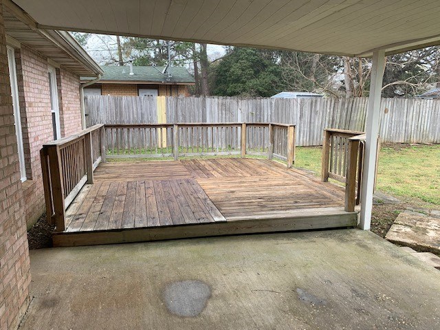 a porch with a wooden floor and a wooden fence
