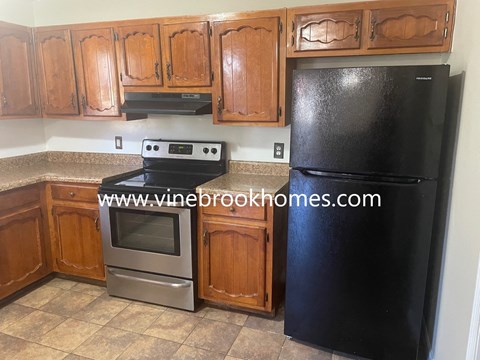 a kitchen with black appliances and wooden cabinets