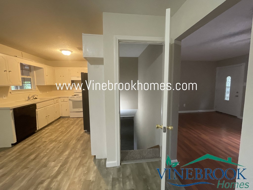 a kitchen and a living room with a door open to a hallway