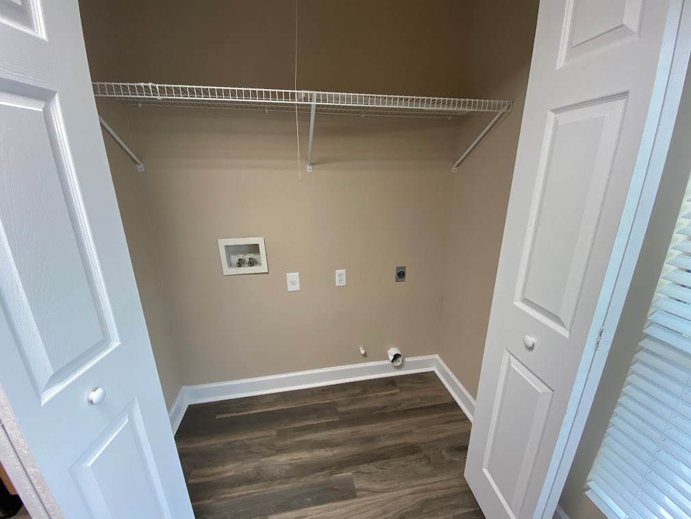 A white door is on the left and right of a room with a shelf and a picture on the wall.