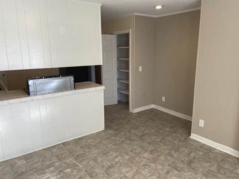 A kitchen with white cabinets and a tiled countertop.