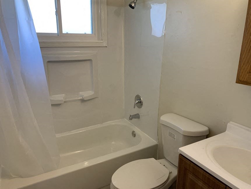 a bathroom with a toilet and a tub and a sink
