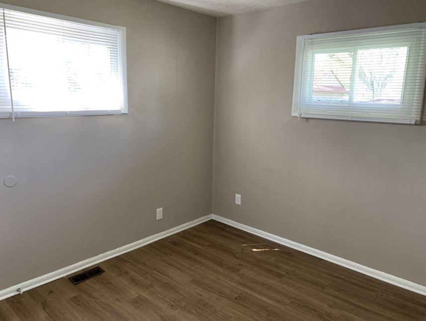 a empty room with a wooden floor and a window