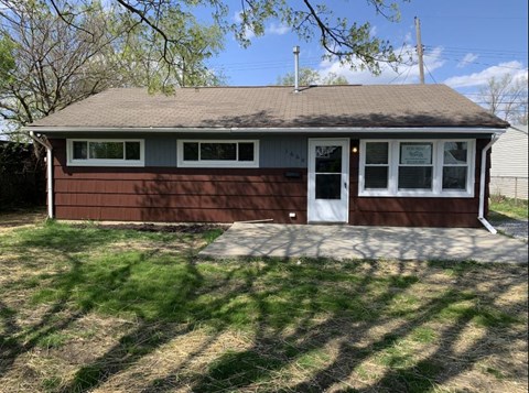 a small house with a front porch and a driveway